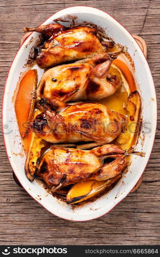 Carcasses of quail roasted with orange sauce. Baked whole quails