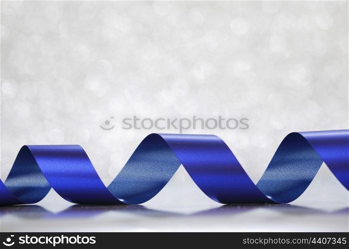 Card with blue gift bow on shiny silver background