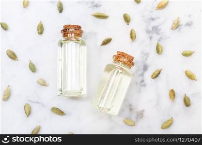 Cardamom essential oil on marble table. Elettaria cardamomum. Top view
