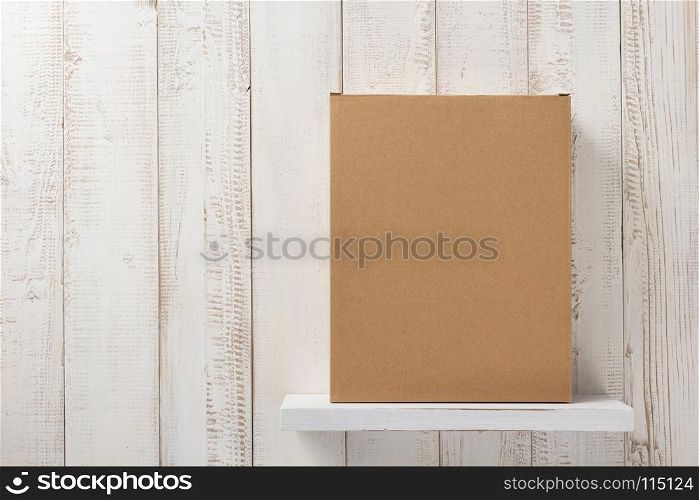 cardboard box on white wooden shelf