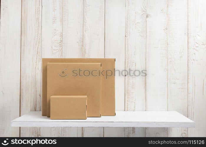 cardboard box on white wooden shelf