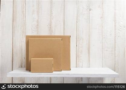 cardboard box on white wooden shelf