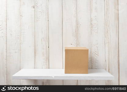 cardboard box on white wooden shelf