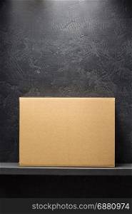cardboard box on wooden shelf black background surface