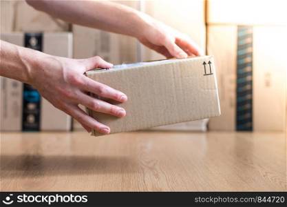 Cardboard box shipping concept: Man is holding a brown parcel