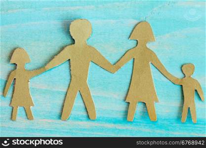 Cardboard figures of the family on a bluewooden background
