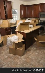 Cardboard moving boxes with bubble wrap in kitchen.