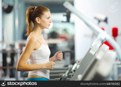 Cardio workout. Image of fitness girl running on treadmill