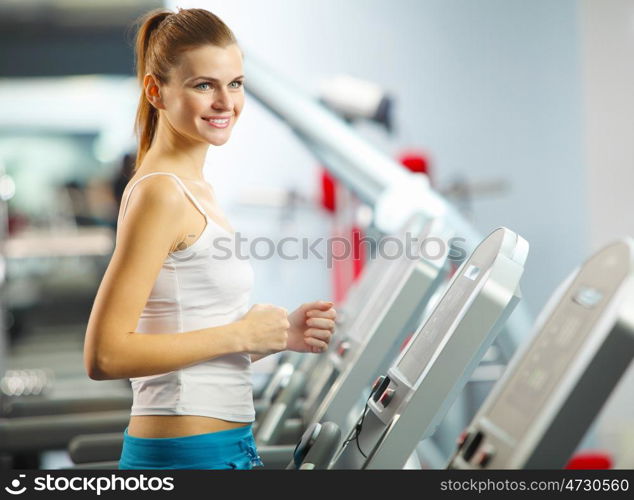 Cardio workout. Image of fitness girl running on treadmill