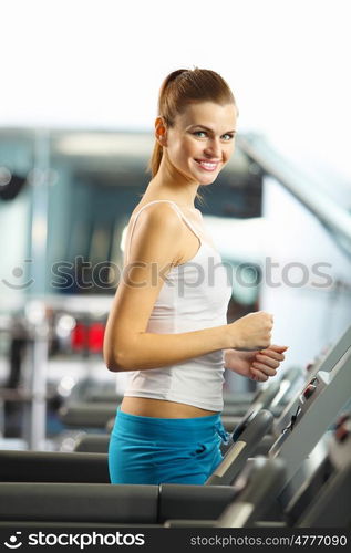 Cardio workout. Image of fitness girl running on treadmill