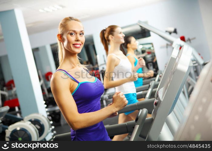 Cardio workout. Image of fitness girl running on treadmill