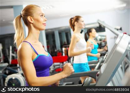 Cardio workout. Image of fitness girl running on treadmill