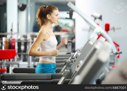 Cardio workout. Image of fitness girl running on treadmill