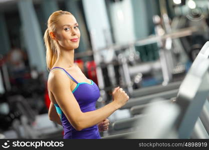 Cardio workout. Image of fitness girl running on treadmill