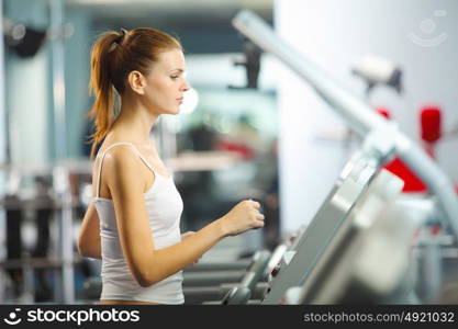 Cardio workout. Image of fitness girl running on treadmill