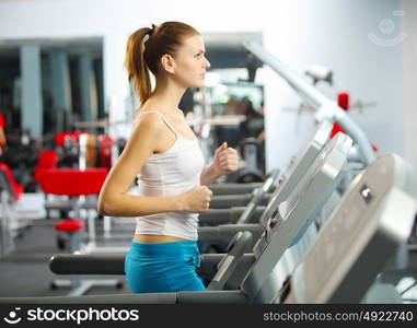 Cardio workout. Image of fitness girl running on treadmill