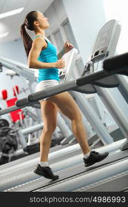 Cardio workout. Image of fitness girl running on treadmill