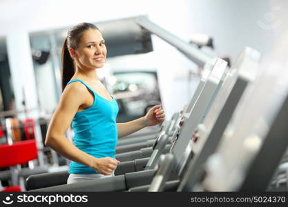 Cardio workout. Image of fitness girl running on treadmill