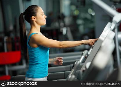 Cardio workout. Image of fitness girl running on treadmill