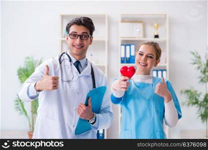Cardiologist with his nurse assistant posing in hospital