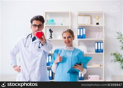 Cardiologist with his nurse assistant posing in hospital