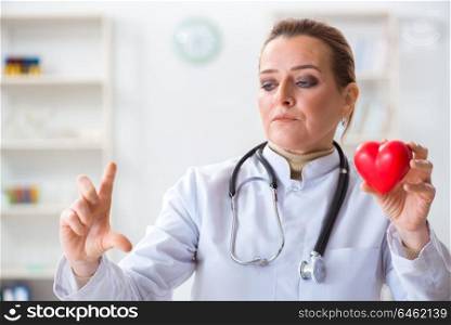 Cardiologist with red heart in medical concept