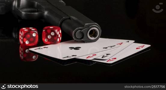 Cards, dice and a gun on a black background. The concept of gambling and entertainment. Casino and poker. gambling poker, closeup