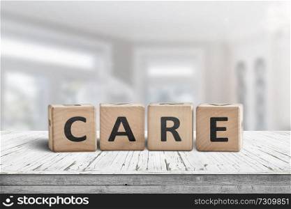 Care sign on a white table in a bright room with a blurry background