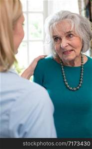 Care Worker Talking To Senior Woman At Home