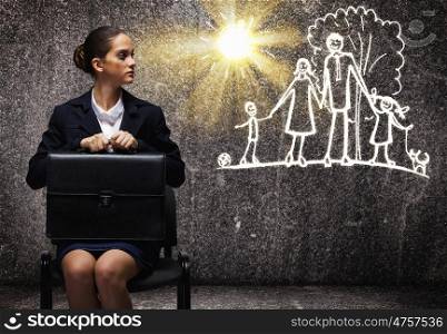 Career or family. Young upset businesswoman sitting on chair with briefcase