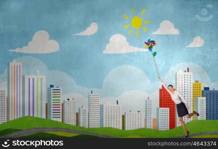 Carefree and happy. Beautiful young caucasian businesswoman flying on windmill