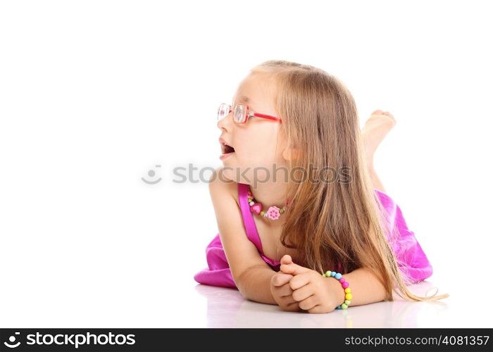 Carefree days of childhood. Cute little girl lying on floor with feet up doing fun studio shot isolated on white background