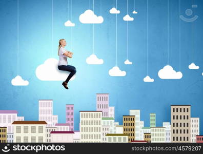 Carefree girl. Young pretty girl riding on cloud high in sky