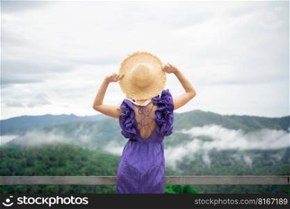Carefree happy woman in morning of nature cliff mountain. Woman travel tourist alone morning freedom and happiness.