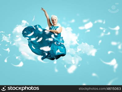 Carefree woman. Young attractive woman in blue dress jumping high