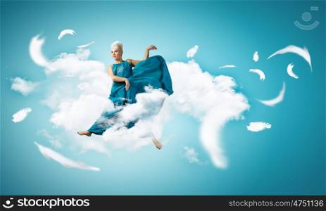 Carefree woman. Young attractive woman in blue dress jumping high