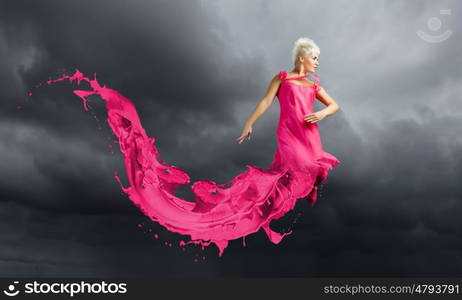 Carefree woman. Young attractive woman in pink dress jumping high