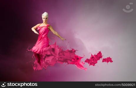 Carefree woman. Young attractive woman in pink dress jumping high