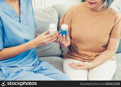 Caregiver advising contented senior woman on medication in the living room. Medication for seniors, nursing house, healthcare at home.. Caregiver advising contented senior woman on medication in the living room.