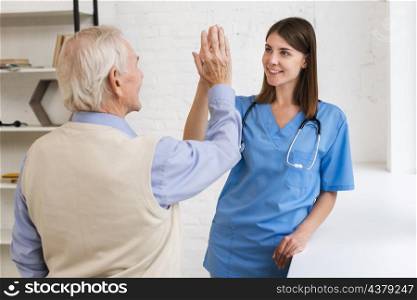 caregiver high fiving with old man