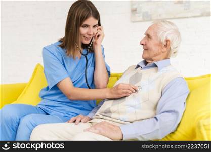 caregiver using stethoscope old man