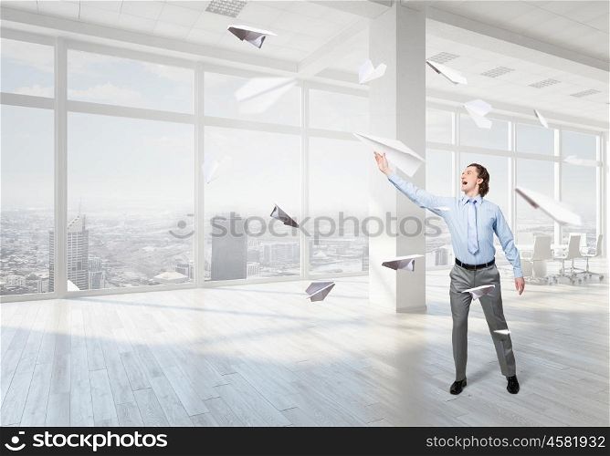 Careless businessman in office. Careless businessman with paper plane in office interior