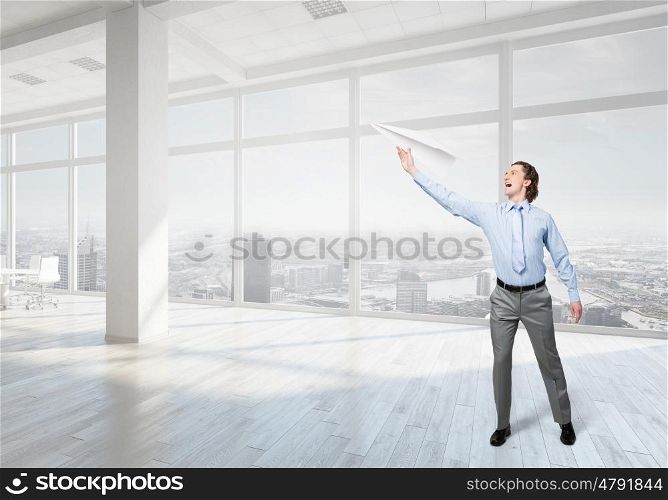 Careless businessman in office. Careless businessman with paper plane in office interior
