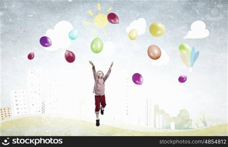 Careless happy child. Little cute boy playing joyfully with colorful balloon