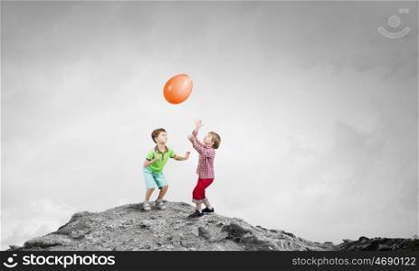 Careless happy child. Little cute boys playing joyfully with colorful balloon