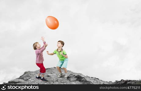 Careless happy child. Little cute boys playing joyfully with colorful balloon