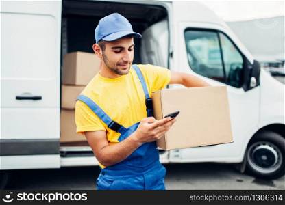 Cargo distribution industry, delivery service. Worker in uniform with box and mobile phone in hands. Empty container