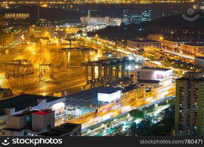 Cargo ship and traffic in Singapore city. light of car on street in night.