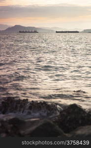 cargo ship Moored at sea. Behind the mountains. In the morning.