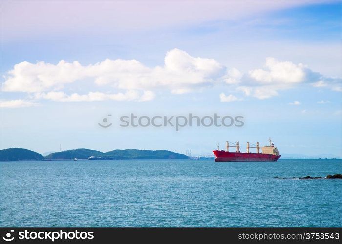 cargo ship Moored at sea. Behind the mountains. In the morning.